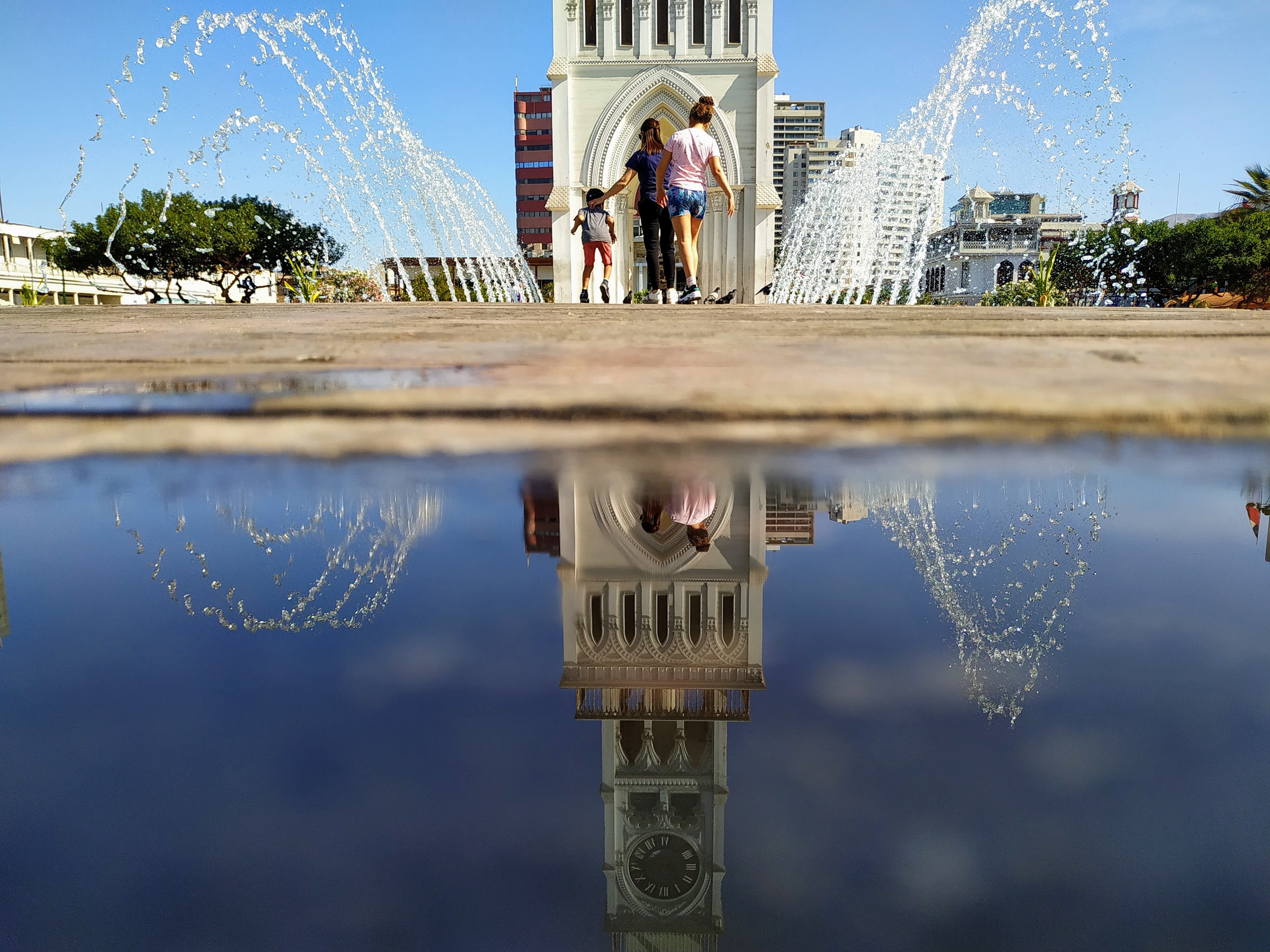 Atardecer cálido sobre la plaza y la torre iluminada